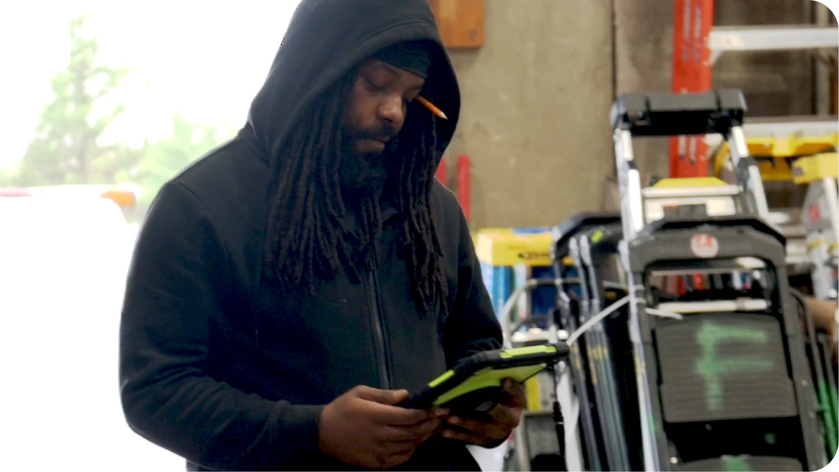 Warehouse worker using tablet for digital pull sheets and real-time inventory tracking 